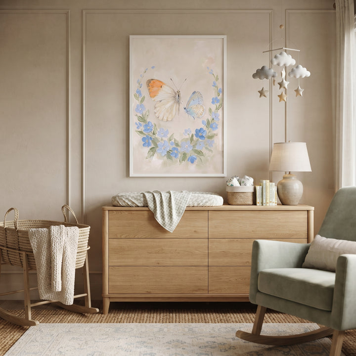 Nursery with wooden dresser, green rocker, and french country floral butterflies wall art on a paneled wall.