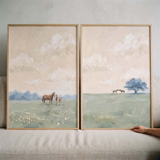 French countryside meadow horse wall art set of 2 shows horses in soft green fields beneath a neutral, cloudy sky.