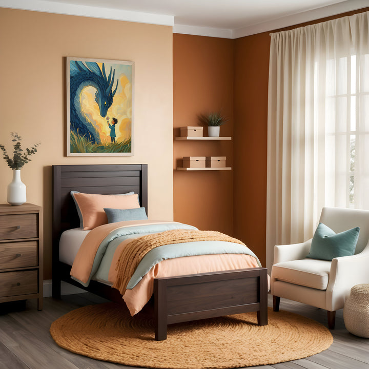 Warm and inviting child’s bedroom with terracotta and beige walls, featuring a dark wood bed with soft peach and light blue bedding atop a round woven rug. Above the bed, a framed illustration shows a young girl standing in a field, gently reaching out to a large blue dragon as golden clouds swirl behind them.