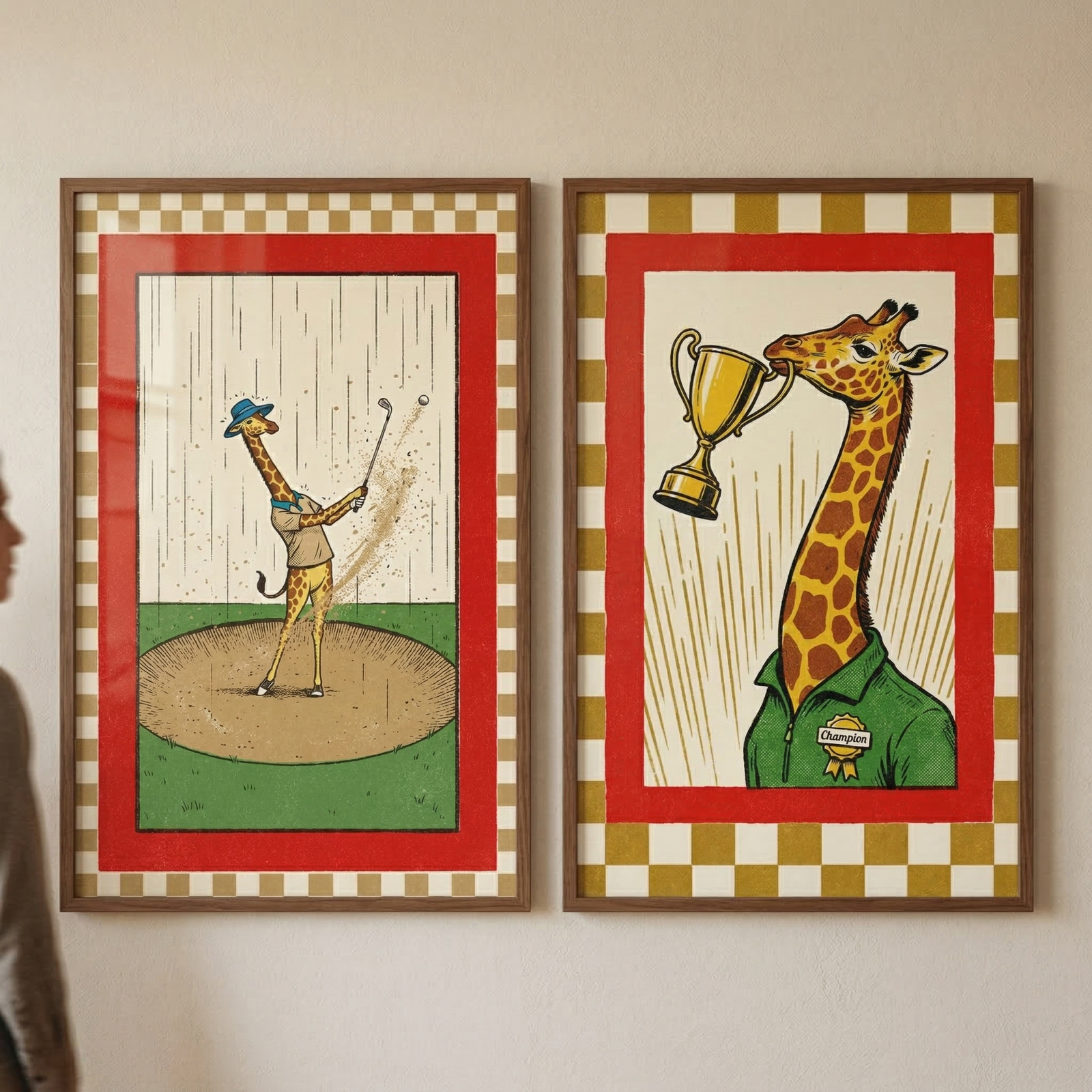 Two vertically oriented, wood-framed illustrations hang side-by-side on a plain wall. Both pieces feature a wide red border inside a gold and cream checkered pattern. 

In the left frame, a cartoon giraffe wearing a blue hat and tan vest swings a golf club while standing in a circular sand bunker. Sand and a golf ball are flying through the air against a background of thin vertical lines. 
