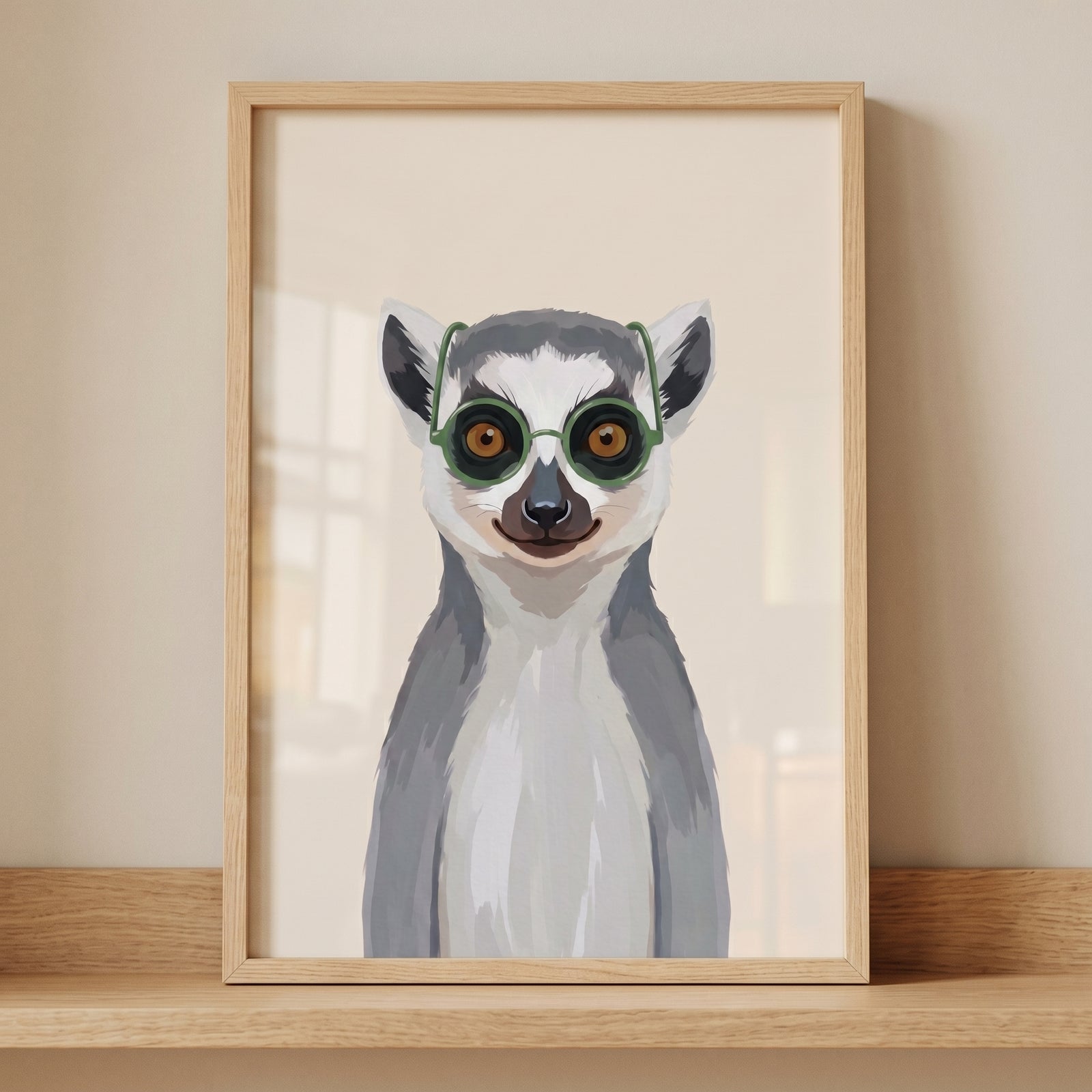 Funny green glasses lemur wall art in a light wood frame resting on a wooden shelf against a beige wall.