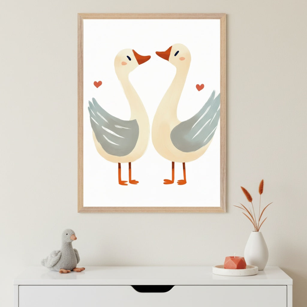 Neutral-toned room with a white dresser. Above it hangs a framed illustration of two stylized geese, facing each other, with red hearts. A plush gray goose, a white vase with dried plants, and a coral candle are on the dresser.