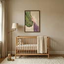 A serene and minimalist nursery is shown, decorated in a calming palette of neutral earth tones. In the center of the room, a light-colored wooden crib sits against a beige wall. A thick, cream-colored cable-knit blanket is draped over the end of the crib, and a small stuffed lamb is nestled inside on the mattress.
Centered on the wall above the crib is a dark-framed artwork. The illustration depicts a hand in a flowing purple robe, representing Jesus.