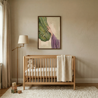 A serene and minimalist nursery is shown, decorated in a calming palette of neutral earth tones. In the center of the room, a light-colored wooden crib sits against a beige wall. A thick, cream-colored cable-knit blanket is draped over the end of the crib, and a small stuffed lamb is nestled inside on the mattress.
Centered on the wall above the crib is a dark-framed artwork. The illustration depicts a hand in a flowing purple robe, representing Jesus.