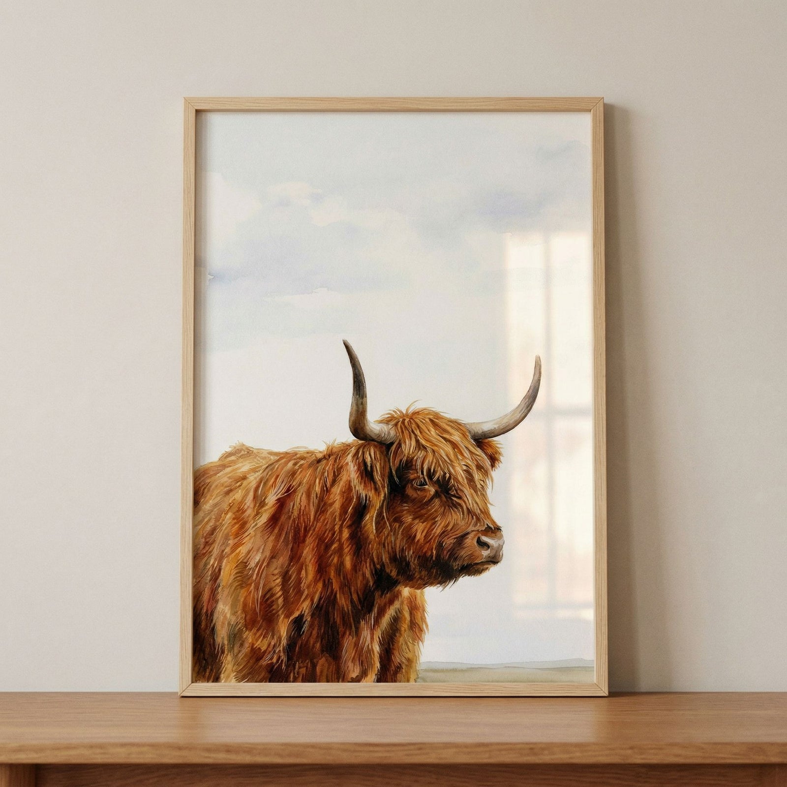Framed ginger fur highland cow wall art featuring a shaggy cow with large horns against a soft cloudy sky.