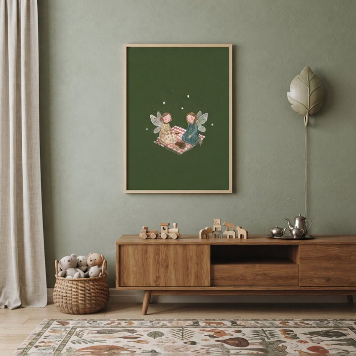 Gingham blanket picnic fairies wall art hangs on a green nursery wall above wooden toys and a basket of stuffed bears.
