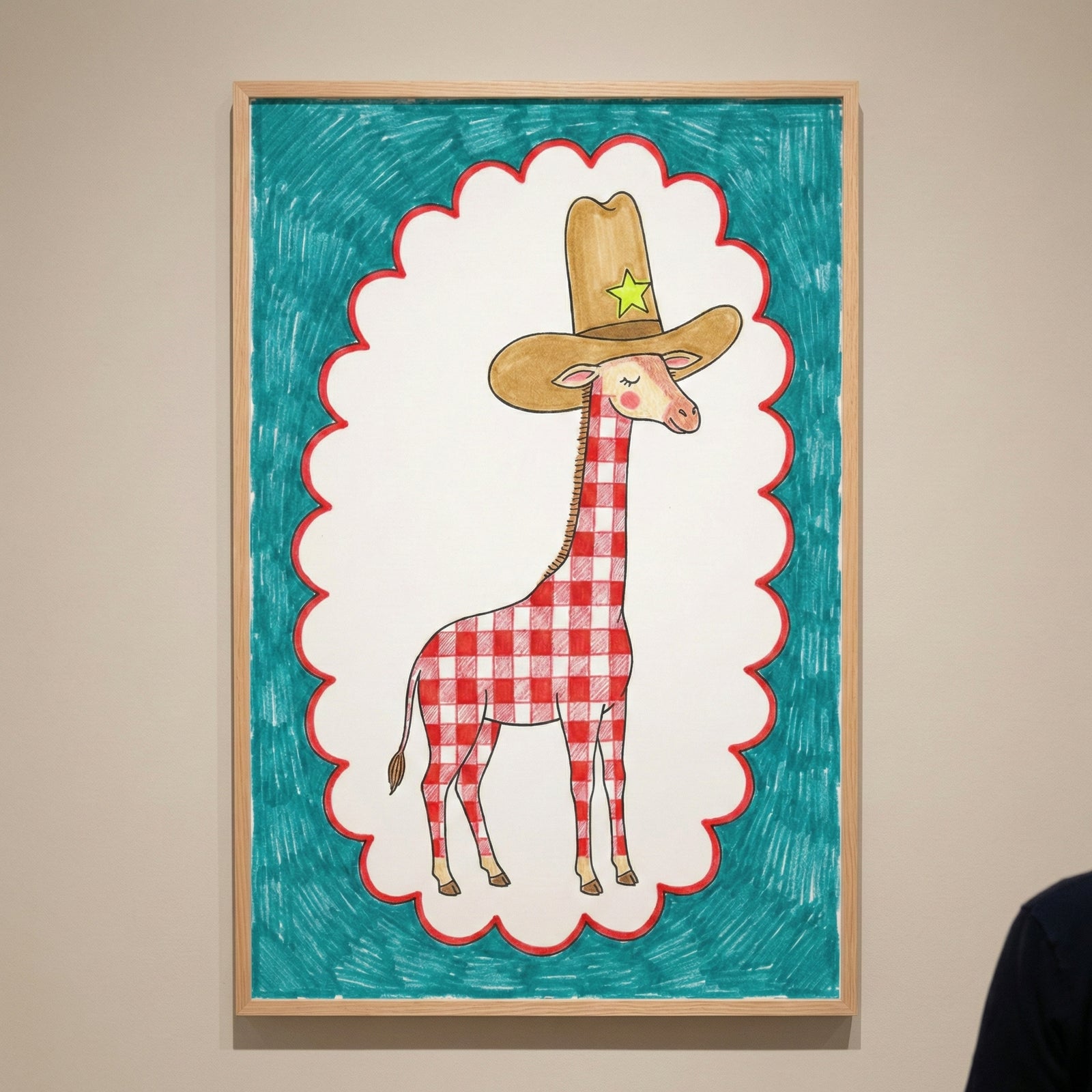 A whimsical framed illustration of a giraffe with a red-and-white checkered body wearing a large cowboy hat with a green star is shown against a teal background. The piece is displayed in a simple wooden frame on a neutral-colored wall.