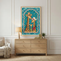 Close-up of a framed drawing of three giraffes in cowboy-themed outfits with hats and bandanas, held against a wall by a hand. The colorful illustration pops with a bright teal sky, yellow stars, and a scalloped red-and-white border, giving it a cheerful western vibe.