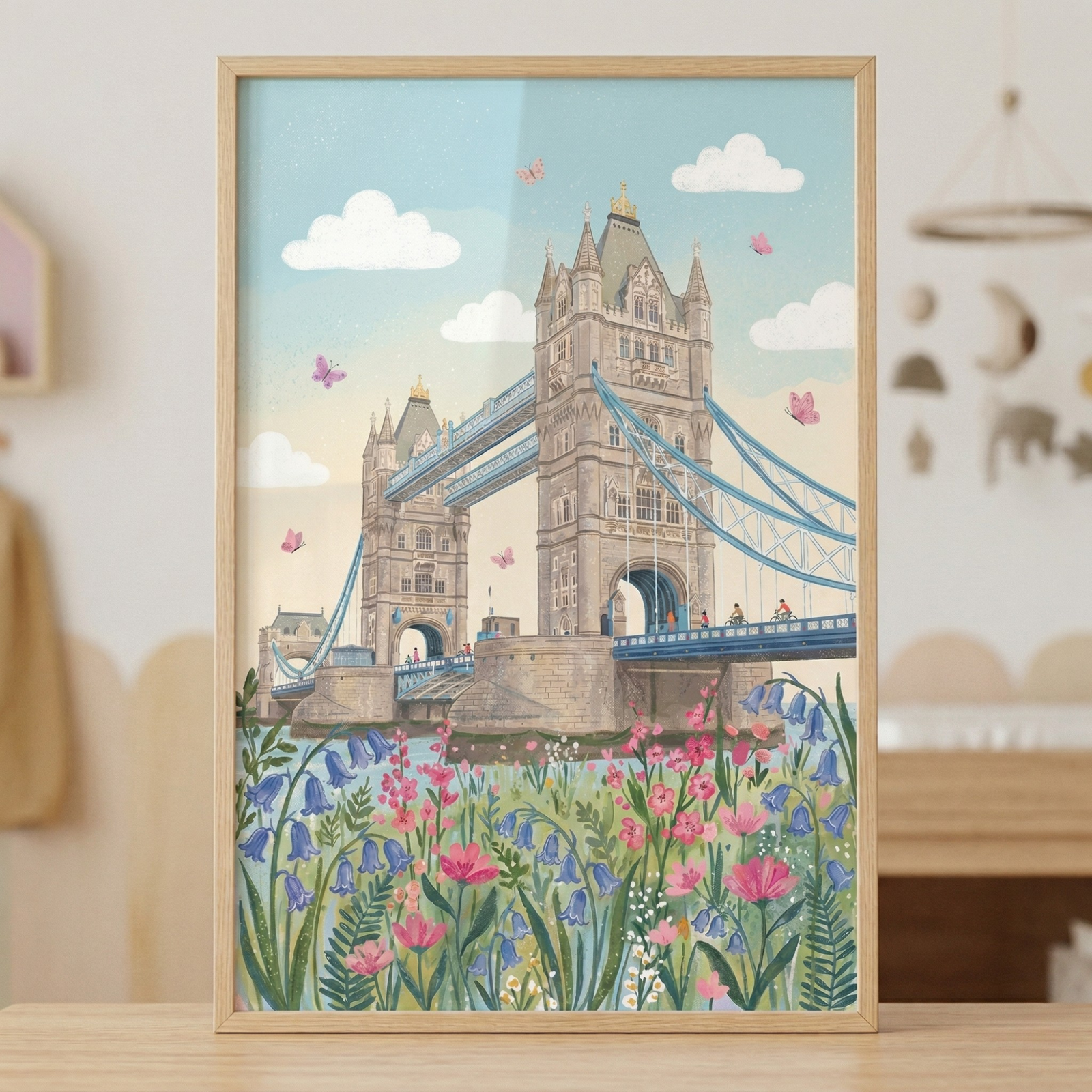 A framed illustration of Tower Bridge in soft pastel tones with pink and purple flowers in the foreground and butterflies floating in a bright sky with light clouds.