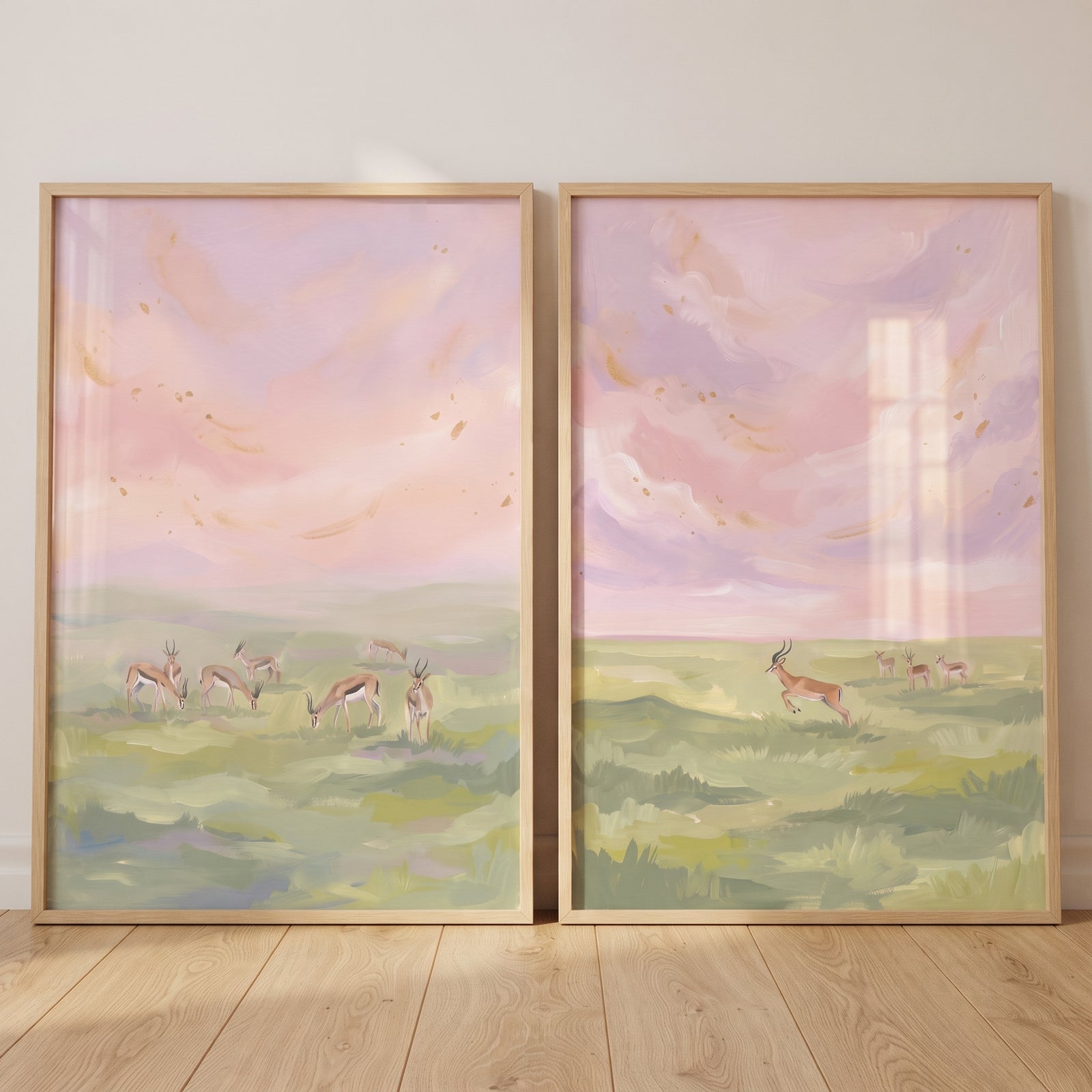 Two framed prints of a gold flecked sky gazelle animals wall art set of 2 in pastel pink and green tones.