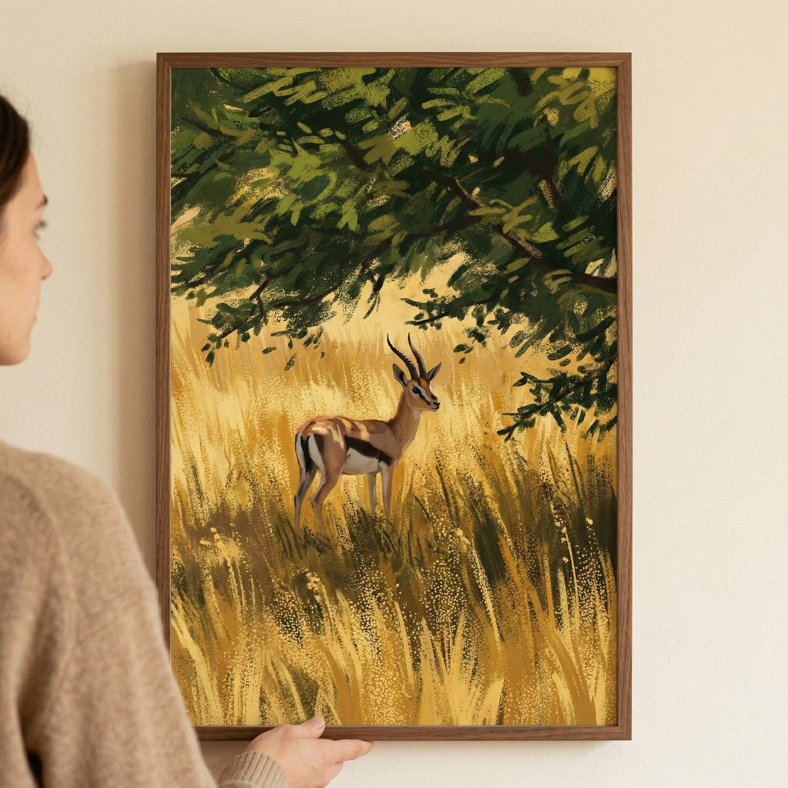 A framed digital art piece shows a horned gazelle standing in a field of tall, golden-yellow grass. Above the animal, a large tree with dense green foliage provides a canopy, casting dappled light and shadows over the scene. 