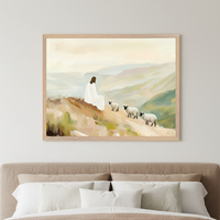 Bedroom with a beige upholstered bed. Above the bed, a framed painting shows a figure in white sitting on a hill with three sheep walking, set against mountains in an impressionistic, brushstroke style.