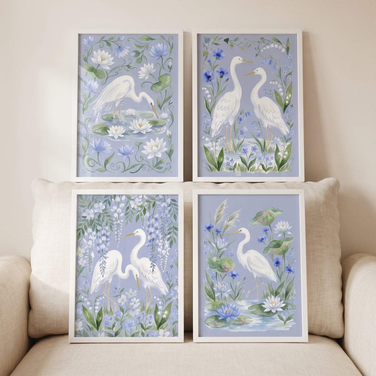 Grandmillennial blue floral heron bird wall art set of 4 features white herons and blue flowers in white frames.
