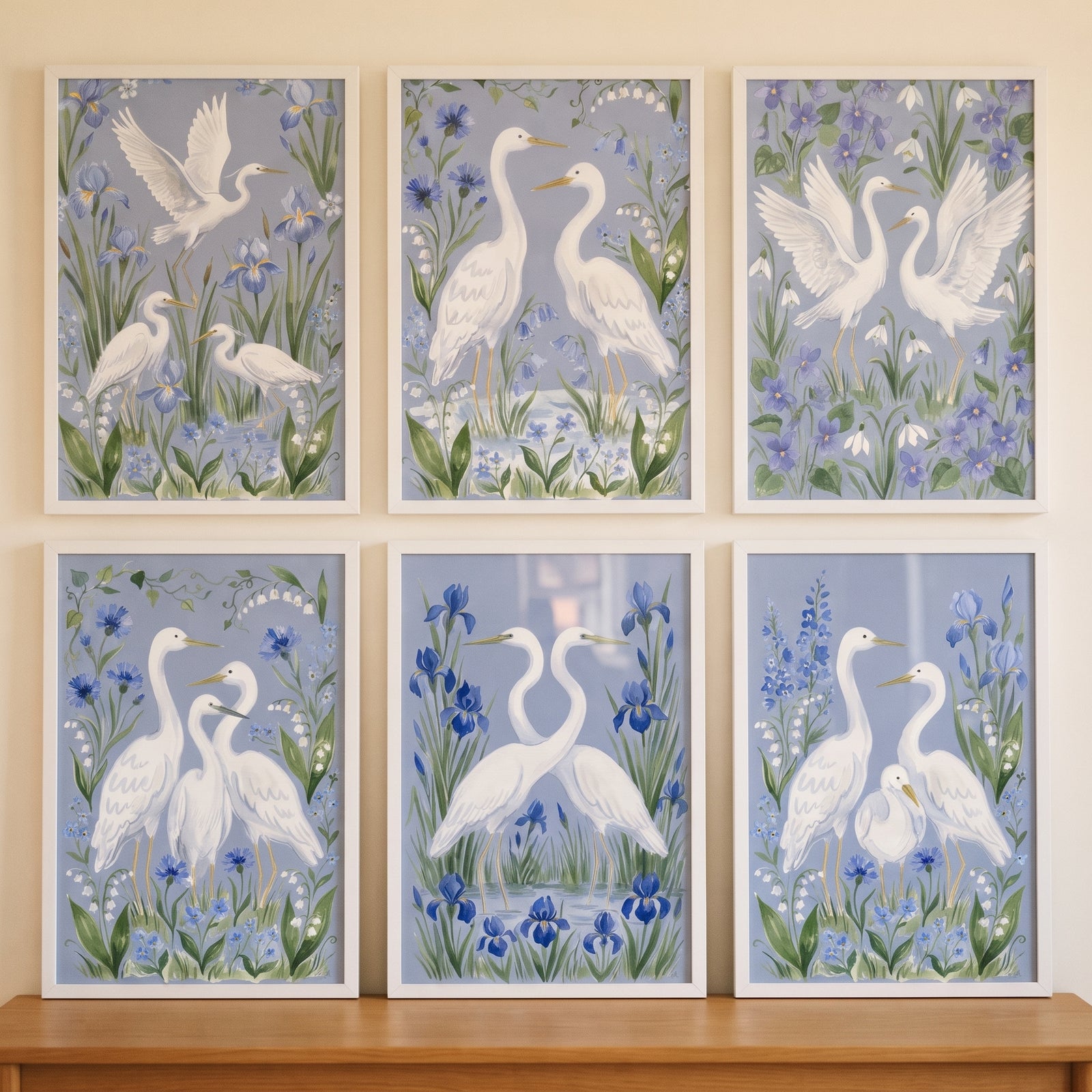 Grandmillennial blue white egret bird wall art set of 6 with white herons and flowers in white frames.