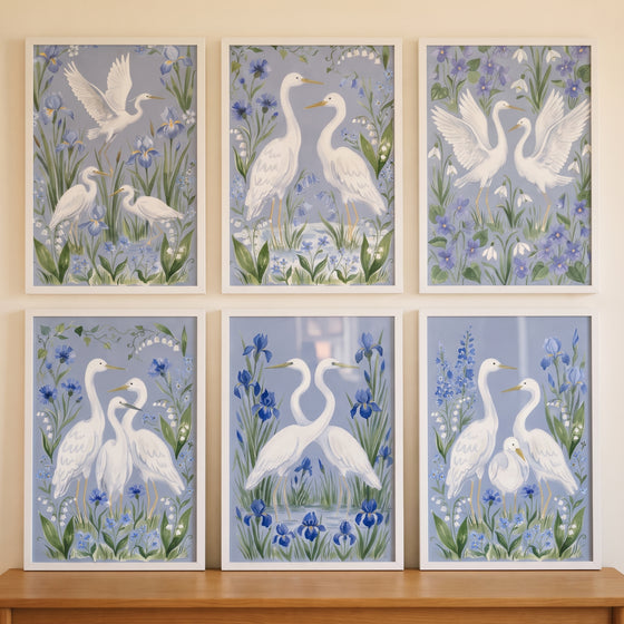 Grandmillennial blue white egret bird wall art set of 6 with white herons and flowers in white frames.