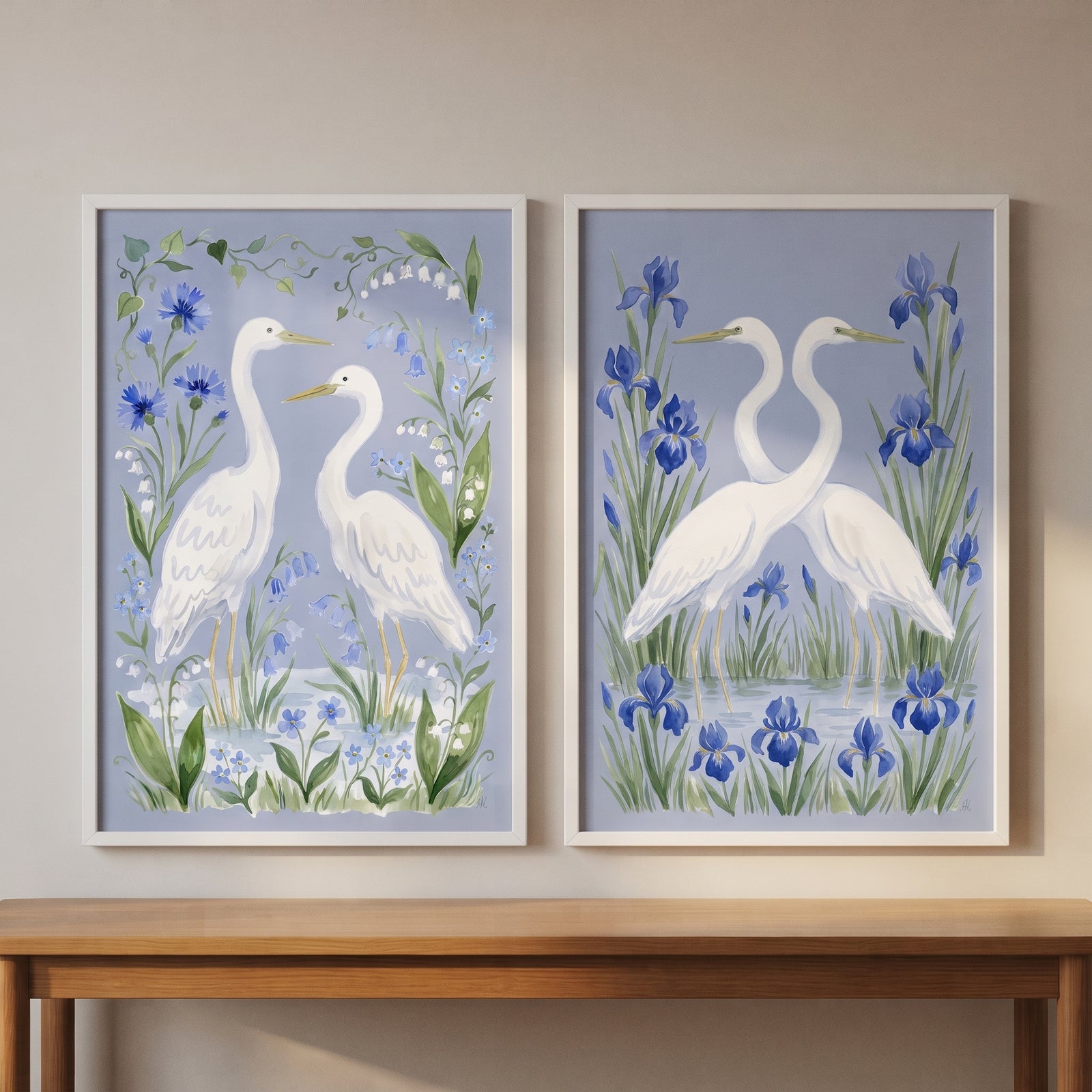 Grandmillennial botanical blue heron bird artwork set of 2 features white herons in blue floral gardens above a table.