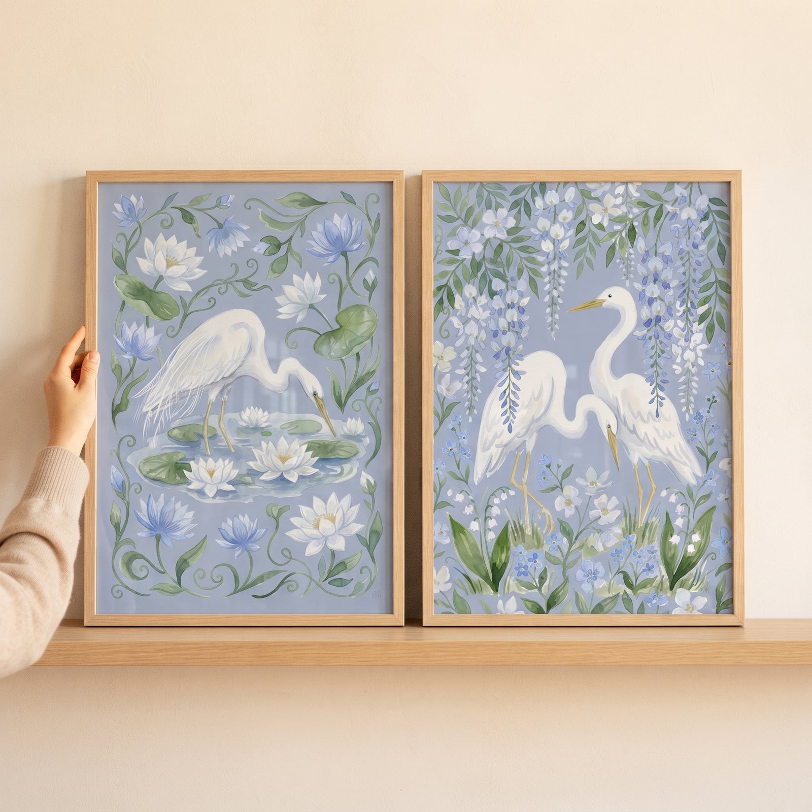 Grandmillennial floral white heron bird wall art set of 2 on a shelf, featuring herons among lilies and blue wisteria.