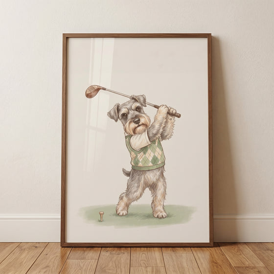 Green argyle sweater schnauzer dog wall art in a wood frame shows a gray dog swinging a golf club over a tee.