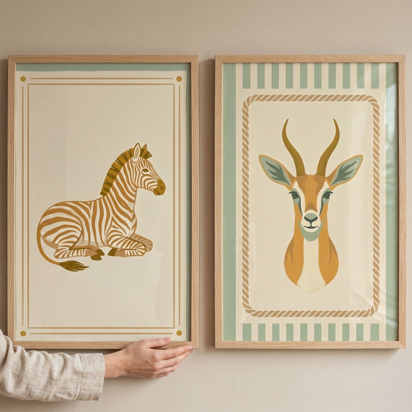 Green folk savanna animal wall art set of 2 with zebra and gazelle illustrations in wooden frames, held by a hand.