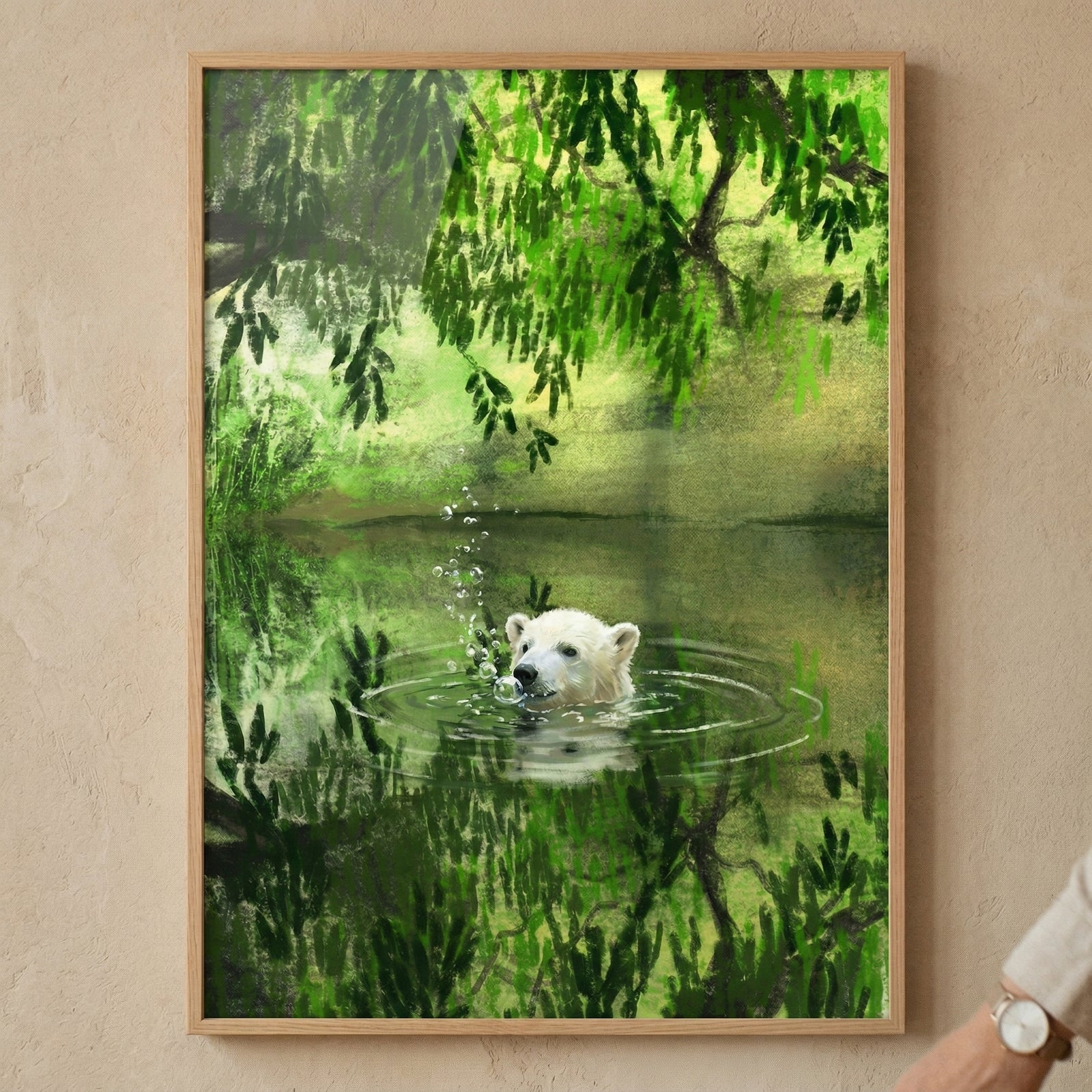 A framed digital illustration hangs on a textured, light beige wall. The scene depicts a white bear's head emerging from a still, green pool of water. Small ripples and bubbles surround its snout. Lush green foliage and overhanging leaves fill the upper portion, their vibrant shades reflected on the water below. The artwork utilizes textured brushwork for a soft, layered effect. It is enclosed in a slim, light-wood frame. A person's wrist with a watch is visible in the bottom right corner.