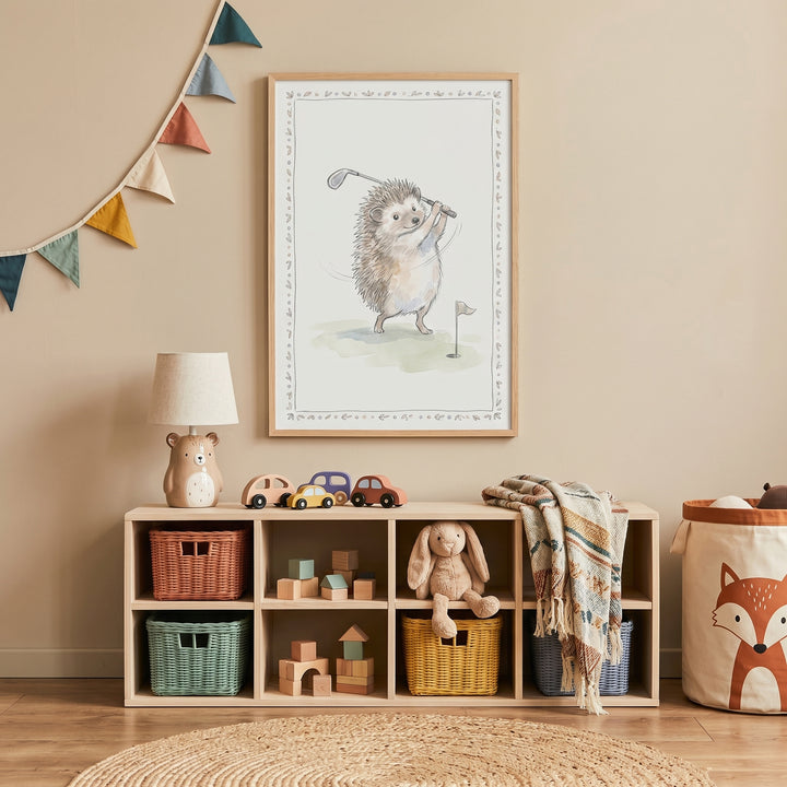 Green grass golf hedgehog wall art hangs over a wooden toy shelf with colorful baskets and a stuffed bunny in a nursery.