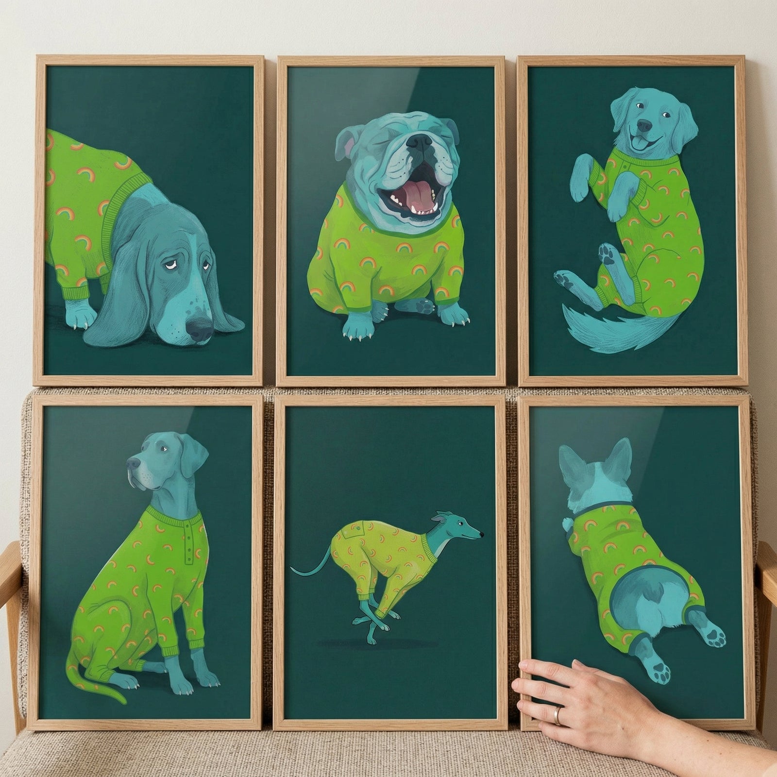 This collection features six framed digital illustrations of various dogs, each set against a deep teal background. Every dog is depicted in a soft turquoise hue and is dressed in bright lime-green pajamas adorned with a whimsical orange rainbow pattern. The frames are made of light-toned natural wood and are arranged in two rows of three.
