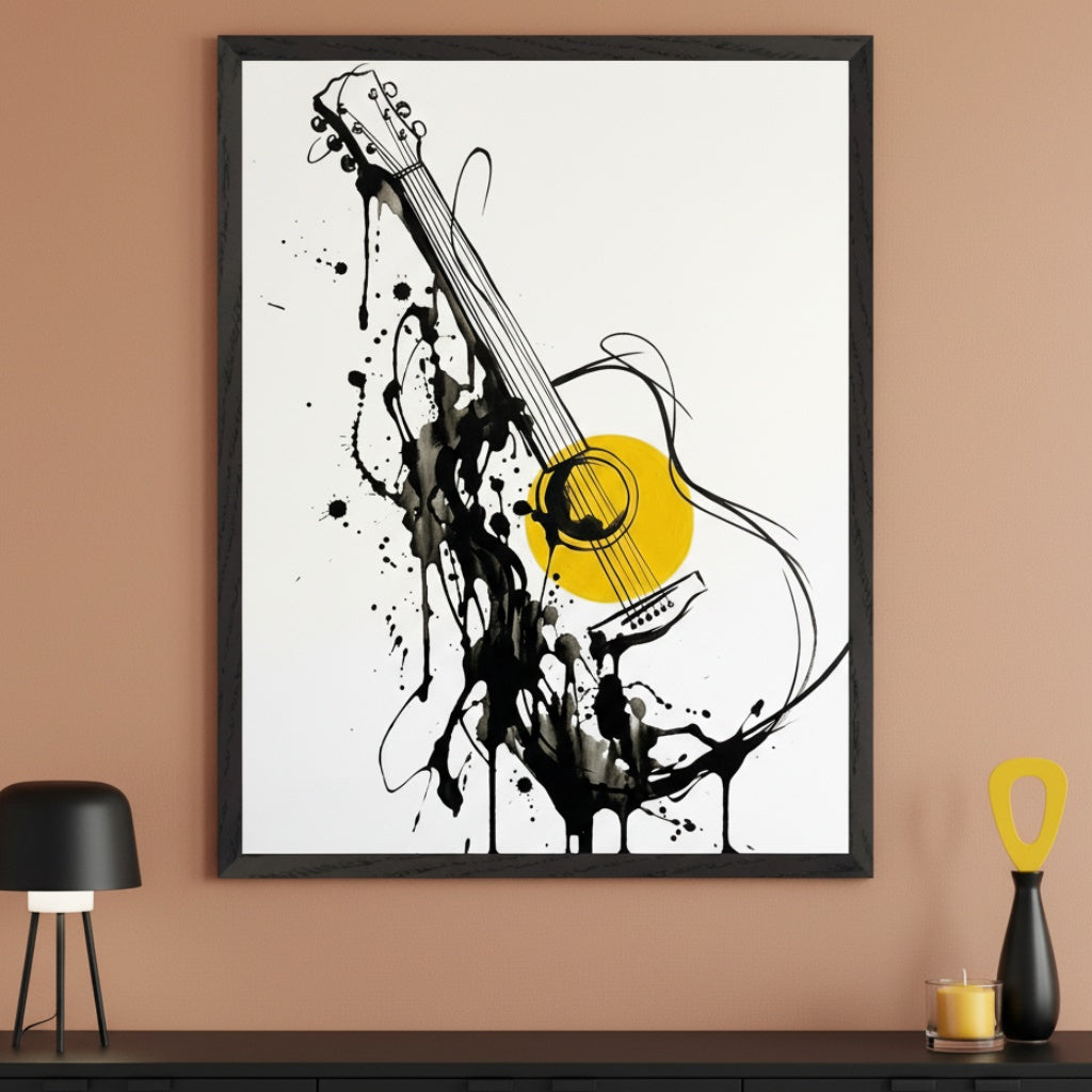Modern room with a warm beige wall and a black console table. A large framed print of an abstract black line art acoustic guitar with black ink splatters and a yellow soundhole hangs above the table. A black lamp, vase, and candle are on the table.