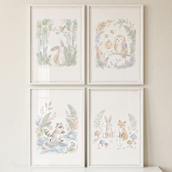 Four watercolor illustrations featuring a hand sketched woodland animal wall art set of 4 in white frames on a beige wall.