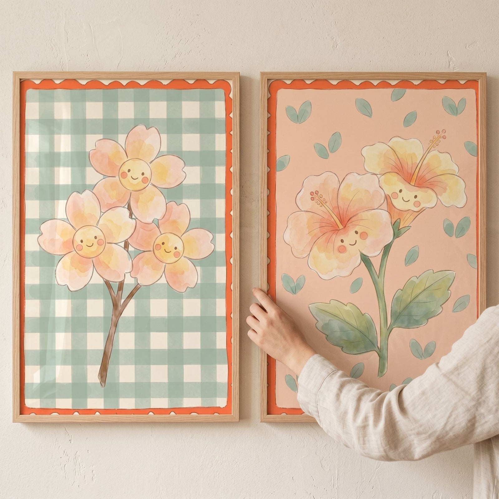 Happy expression smiling flower print set of 2 in wood frames on a wall as a person's hand touches the right frame.
