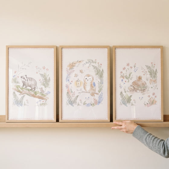 Hazy botanical forest animals wall art set of 3 featuring a badger, owl, and turtle displayed on a shelf.