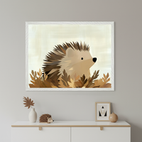 Framed illustration of a cute hedgehog nestled in autumn leaves, with soft brown and beige tones creating a cozy woodland vibe. The artwork is displayed above a modern dresser decorated with a hedgehog figurine, a white vase with a wooden leaf, and minimalist accessories for a warm, nature-themed interior.