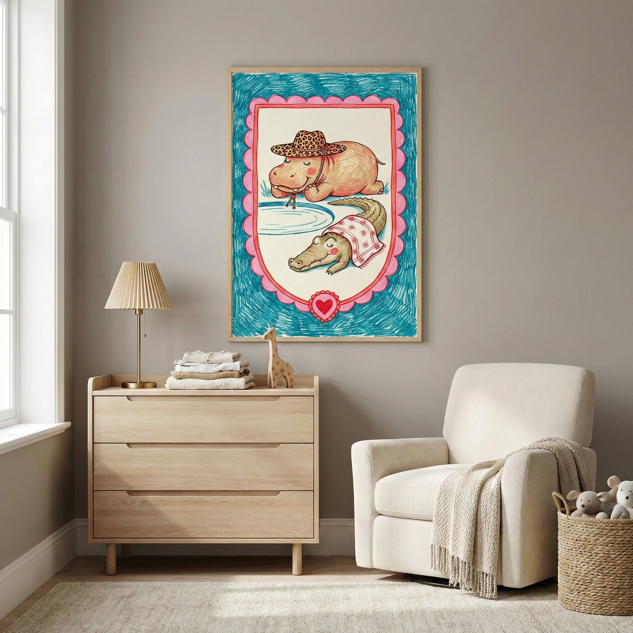 Framed illustration of a hippo in a leopard-print hat sipping water and a crocodile lounging with a red-patterned towel, displayed on a nursery wall. The artwork adds a whimsical touch to the cozy room, which features a light wood dresser, a cream armchair, and soft toys in a woven basket.