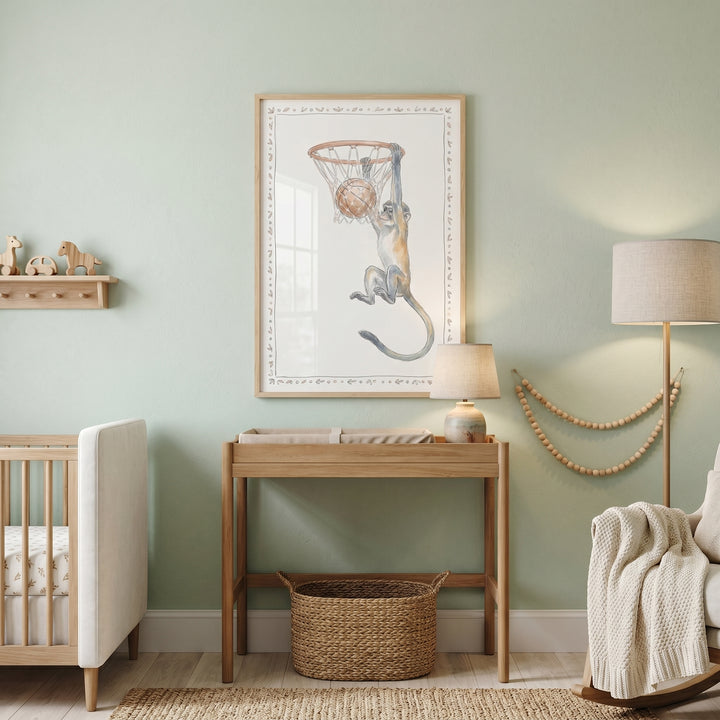 Sage green nursery with a wooden crib, rocking chair, and hoop hanging basketball monkey artwork above a changing table.