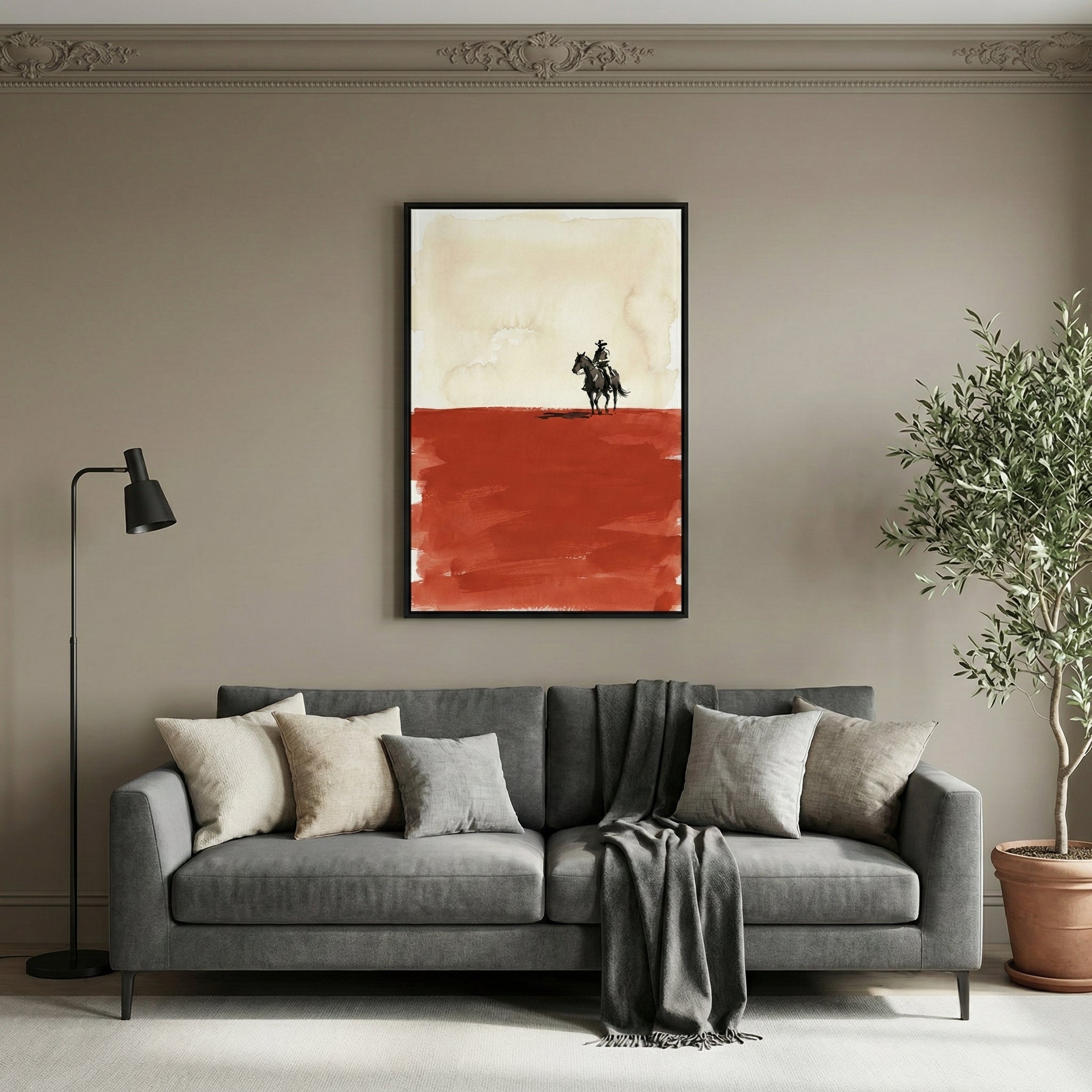 Western-themed painting of a cowboy riding a horse across a red desert, hanging above a modern gray sofa in a neutral-toned living room. The art contrasts a pale sky with a bold rust-colored terrain, adding a rustic yet contemporary touch to the decor.