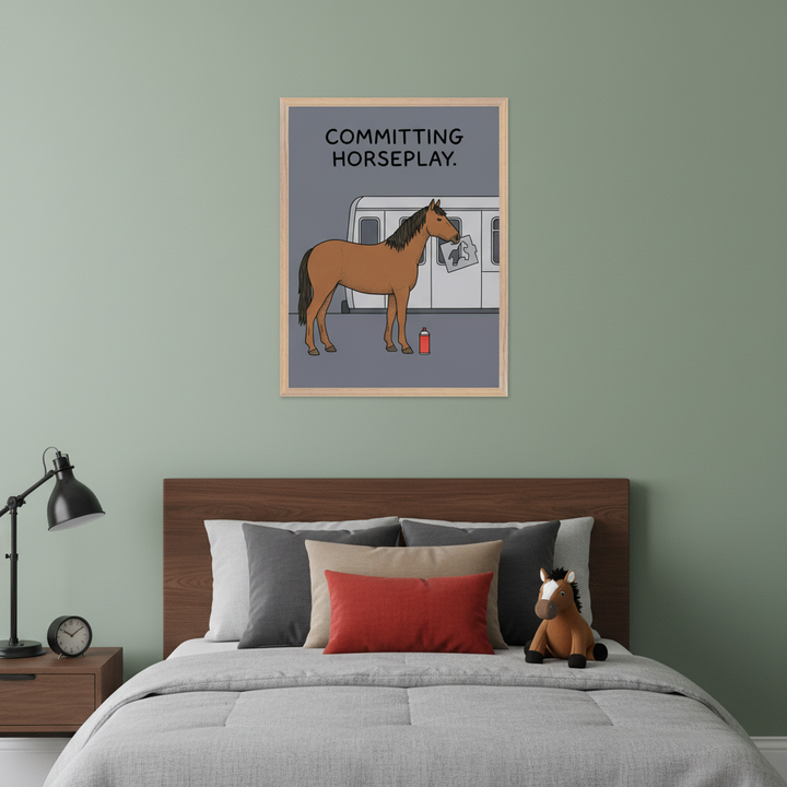 Modern bedroom with a wooden headboard bed. Above the bed hangs a framed cartoon print of a brown horse spray-painting a subway car. Text on the art reads "COMMITTING HORSEPLAY." A nightstand with a lamp is left, and a horse plush is on the bed.