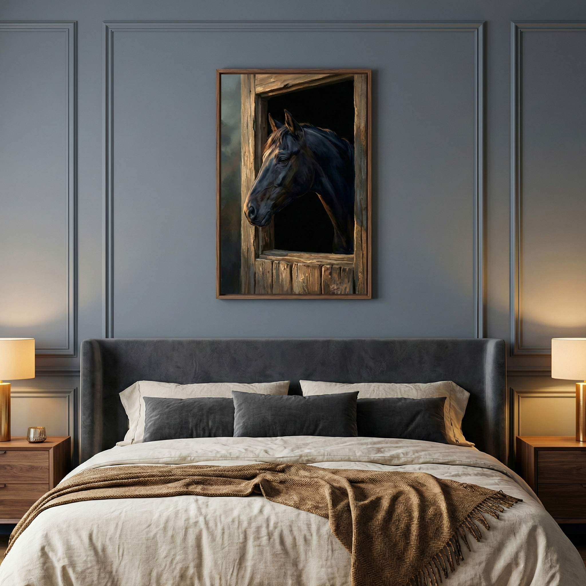 A centered vertical artwork hangs on a slate blue wall with elegant rectangular molding, serving as the focal point above a bed. The art depicts a dark horse looking out from a weathered wooden stable window into a dark interior. Below it, a bed with a plush charcoal grey headboard is neatly made with off-white linens and several accent pillows in shades of grey. A heavy, textured brown throw blanket with fringe is draped across the foot of the bed. 