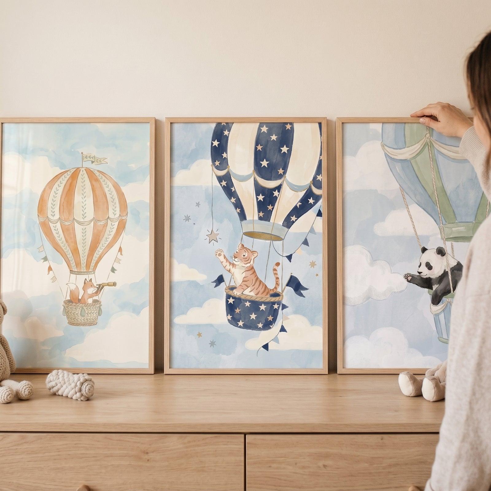 Hot air balloon animals print set of 3 featuring a fox, tiger, and panda in framed watercolor art on a dresser.