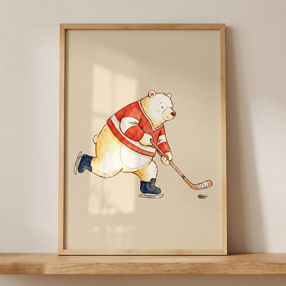 Framed ice hockey bear wall art shows a watercolor cartoon polar bear in a red jersey skating after a hockey puck.