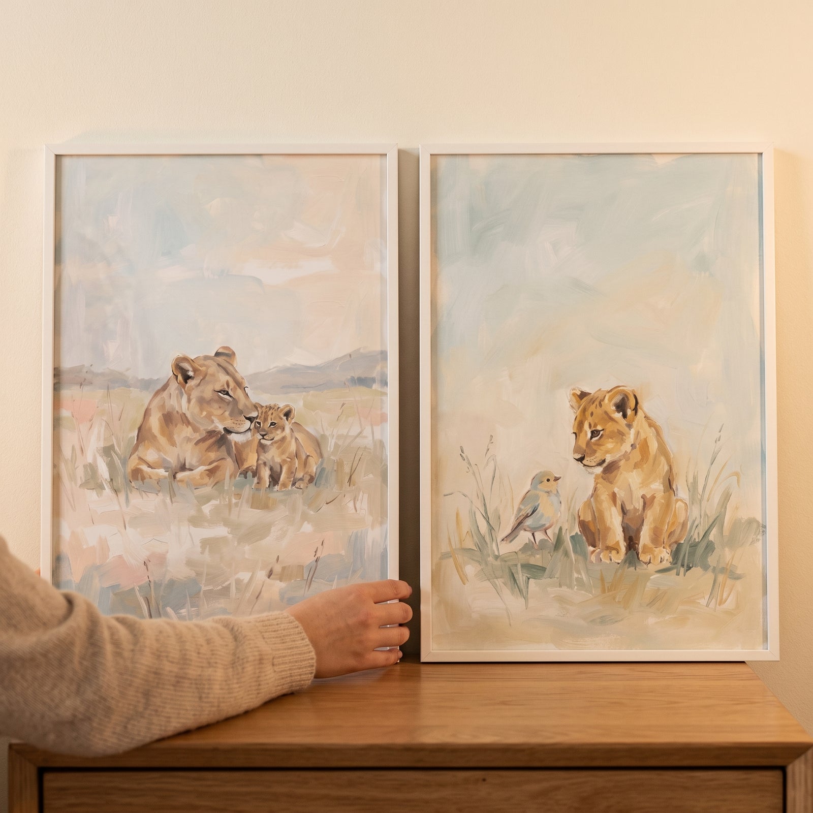 An impressionist baby lion wall art set of 2 featuring a lioness with her cub and a cub with a small bird in soft tones.