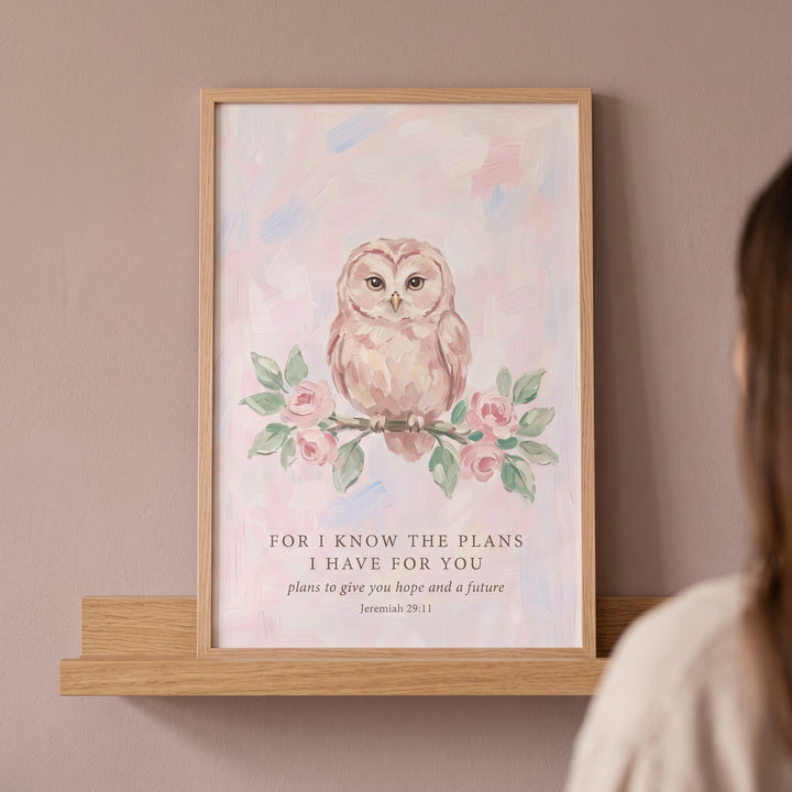 Framed jeremiah 29 11 owl bible wall art with a pink watercolor owl on a branch, resting on a wooden shelf.