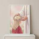A framed soft-toned illustration depicts Jesus gently placing a pink floral crown on a young girl's head. The girl has long blonde hair and wears a simple red dress. Jesus is shown from the torso down, draped in a white robe. The background is a dreamy, hazy garden with hints of pink and green flowers in a watercolor style. This serene art piece is displayed on a white dresser against a neutral wall, creating a peaceful and spiritual atmosphere.