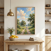 A cozy kitchen scene features a wooden table adorned with a bowl of fresh oranges and a vase of wildflowers. Above the table hangs a framed painting depicting a serene landscape with a person walking a dog down a sunlit path, surrounded by lush greenery and trees under a partly cloudy sky.