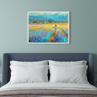 Bedroom with a blue upholstered bed and white pillows. A framed impressionistic painting of a figure in a lavender field with distant mountains hangs centered above the bed.