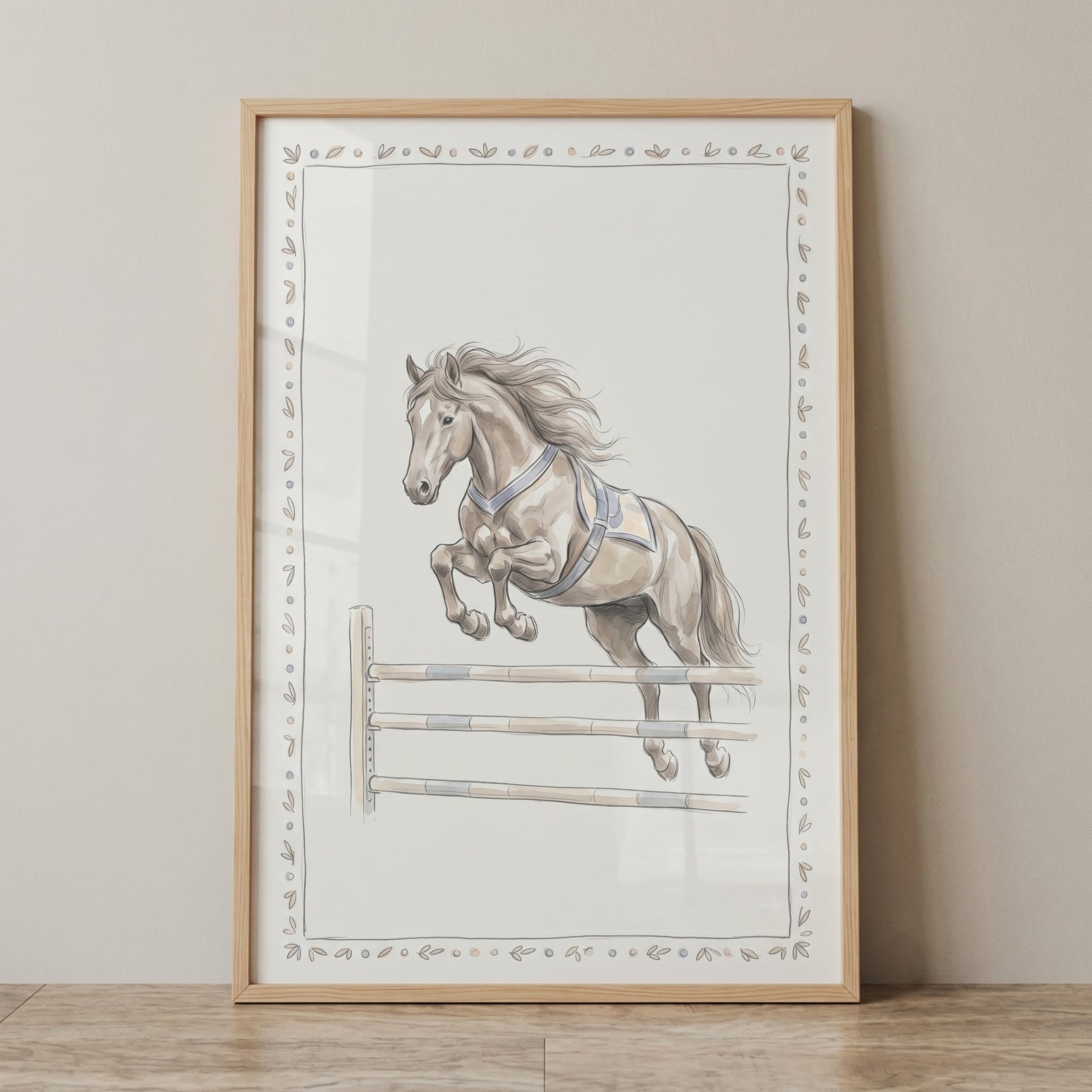Framed jumping horse wall art depicts a light brown horse leaping over a hurdle inside a decorative leaf border.