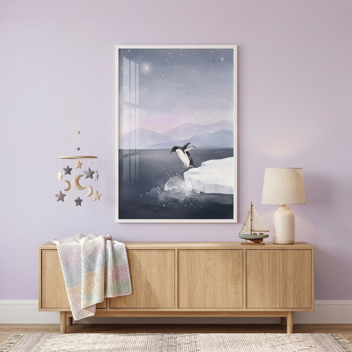 Lavender nursery featuring jumping ice floe penguin wall art above a wooden sideboard with a lamp and hanging mobile.