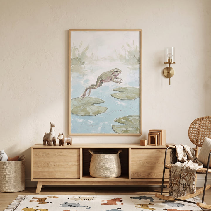 Jumping lily pad frog wall art hangs in a neutral room with a wooden sideboard, rocking chair, and animal pattern rug.