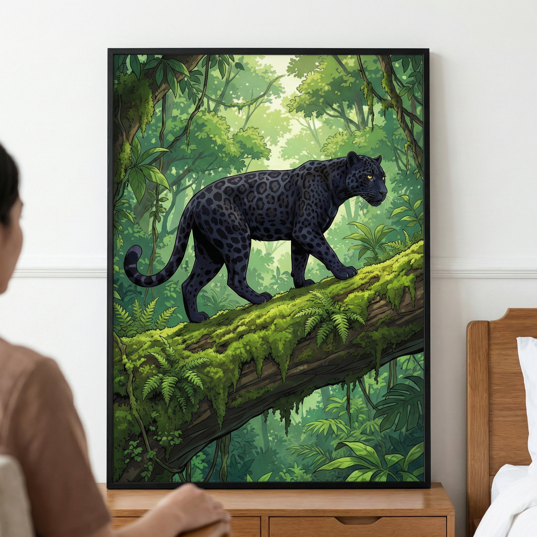 A framed piece of digital artwork displays a large, dark-furred big cat with visible spots, such as a black panther, walking across a massive, moss-covered tree trunk. The animal is set against a vibrant, lush jungle backdrop filled with tropical foliage and sunlight streaming through the trees. The framed print hangs on a plain wall above a wooden dresser, with a person seated in the foreground, partially visible as they view the artwork.