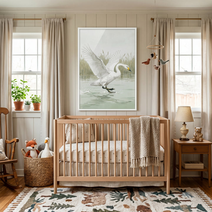 A neutral nursery with a wooden crib, animal rug, and landing whooper white swan wall art between windows.