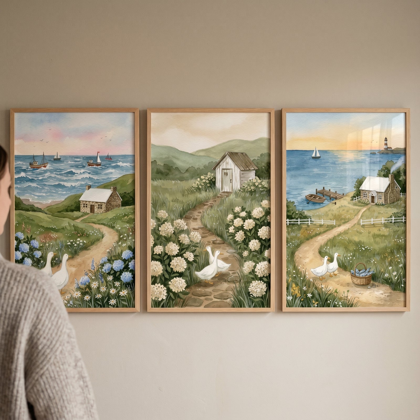 landscape white ducks wall art set of 3 with seaside cottages and stone paths displayed on a neutral wall.