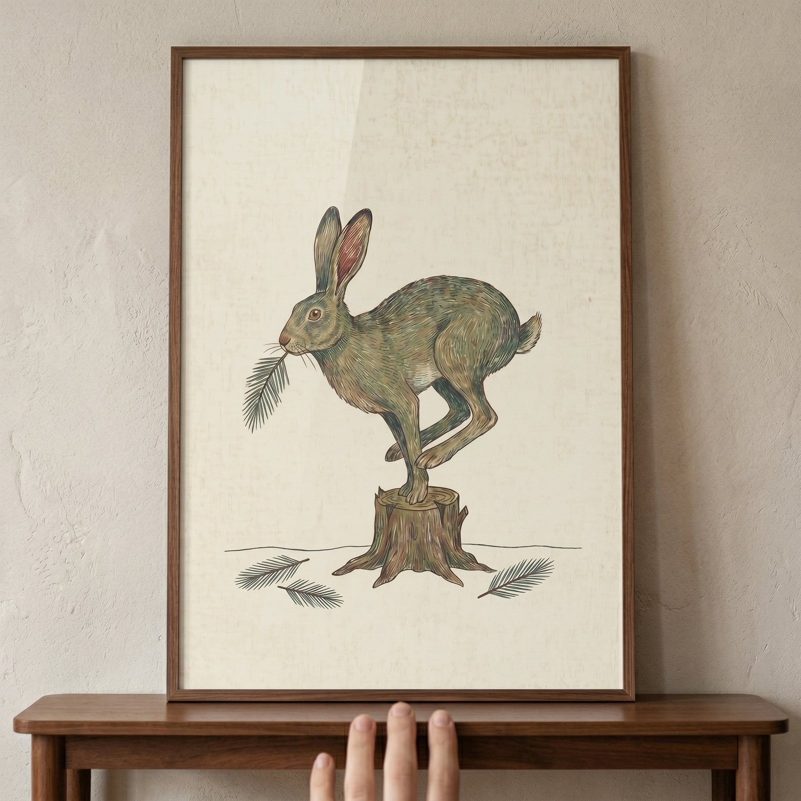 Framed leaping pine needle hare wall art featuring a brown hare on a tree stump with pine sprigs.